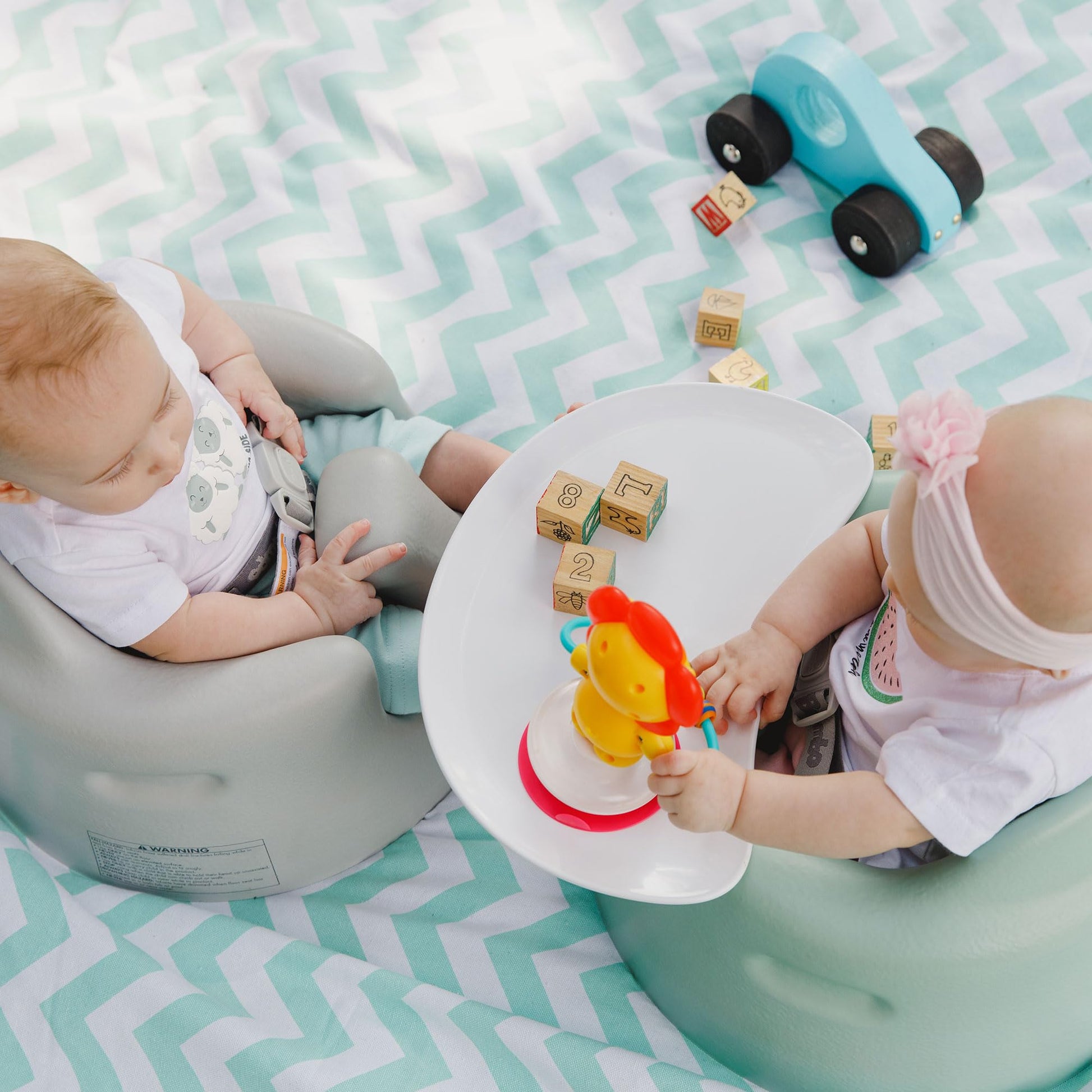 Infant using bumbo seat with play tray attached