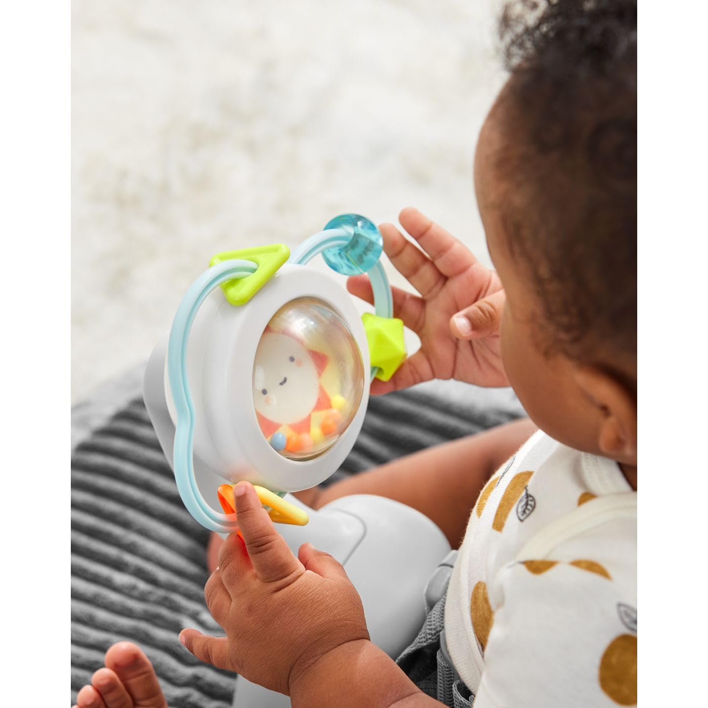 Close up of Skip Hop baby seat plush head support and tactile foot pad