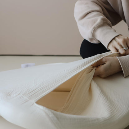 Natural color Snuggle Me muslin cover on baby lounger