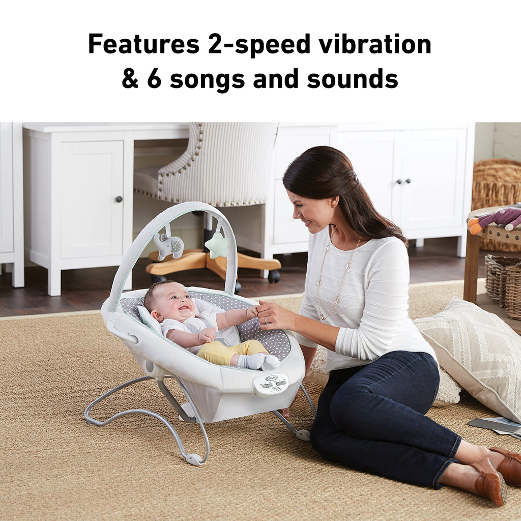 Graco Soothe 'N Sway LX showing the adjustable toy bar with soft plush toys.