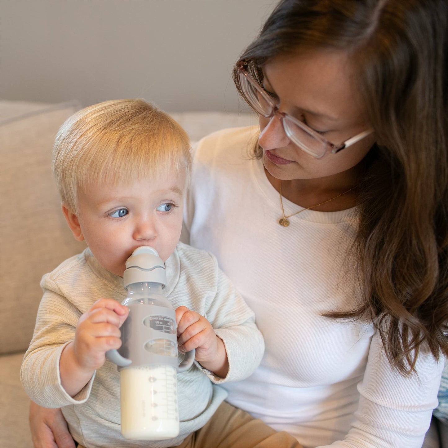Infant holding Dr. Brown's narrow sippy straw bottle