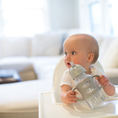 Toddler holding Dr. Brown's Milestones sippy cup