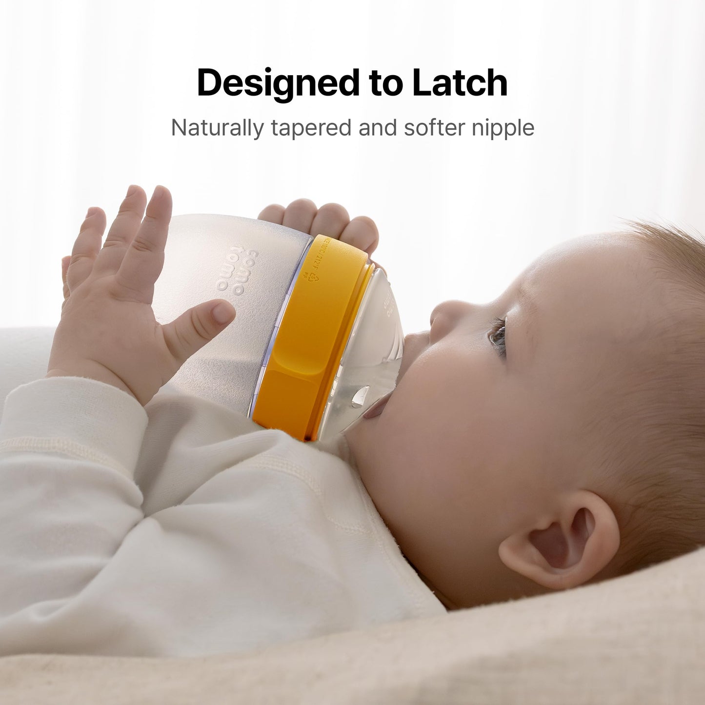 Wide neck yellow Comotomo baby bottles disassembled to demonstrate easy hand washing without brushes.