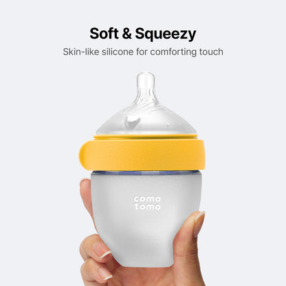Side view of Comotomo yellow five ounce feeding bottle mimicking breast texture for easy transition.
