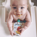 Child holding food pouch with ChooMee SoftSip topper