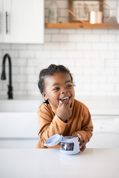 Ubbi Tweat snack container held by small child hands