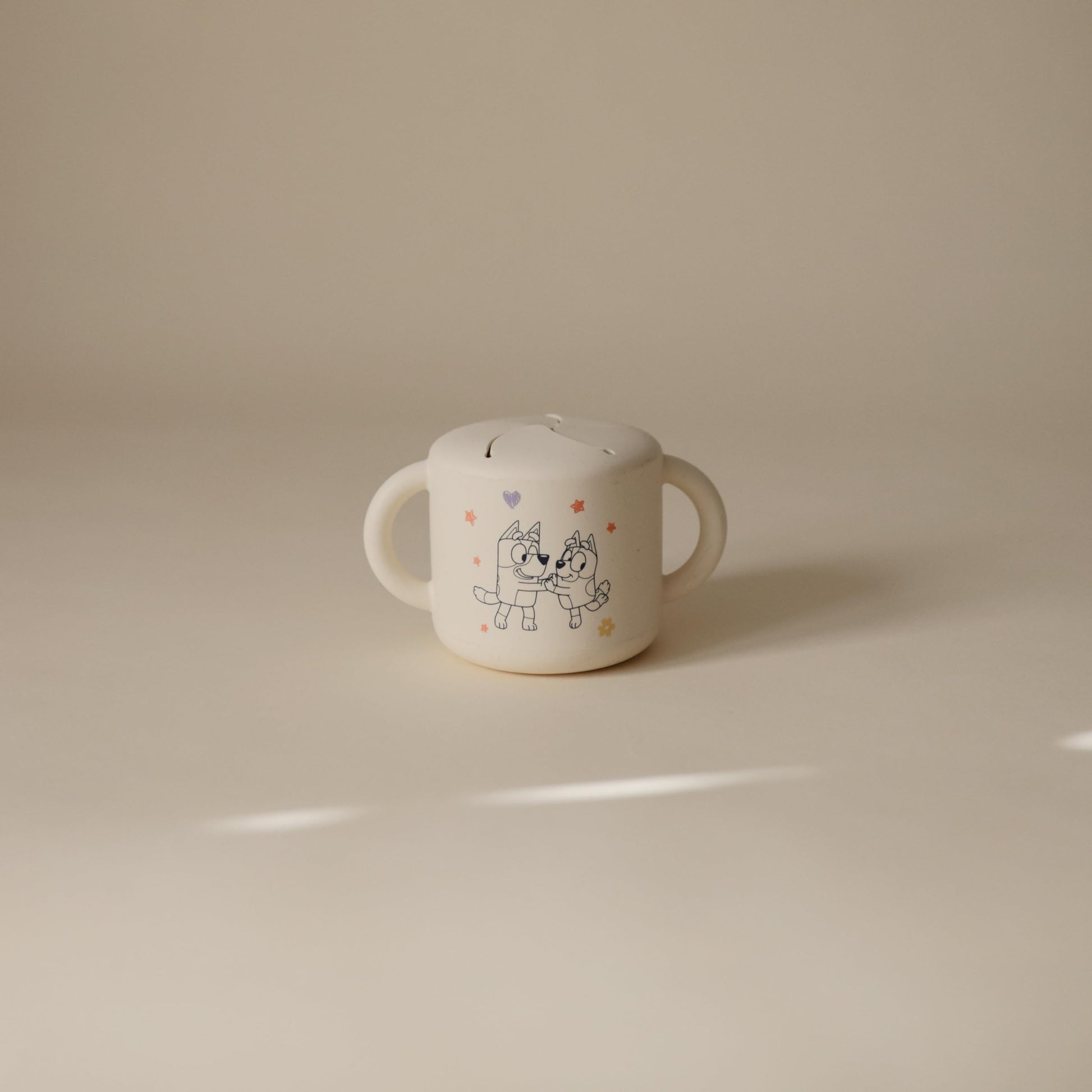 Mushie beige snack cup with easy-grip handles