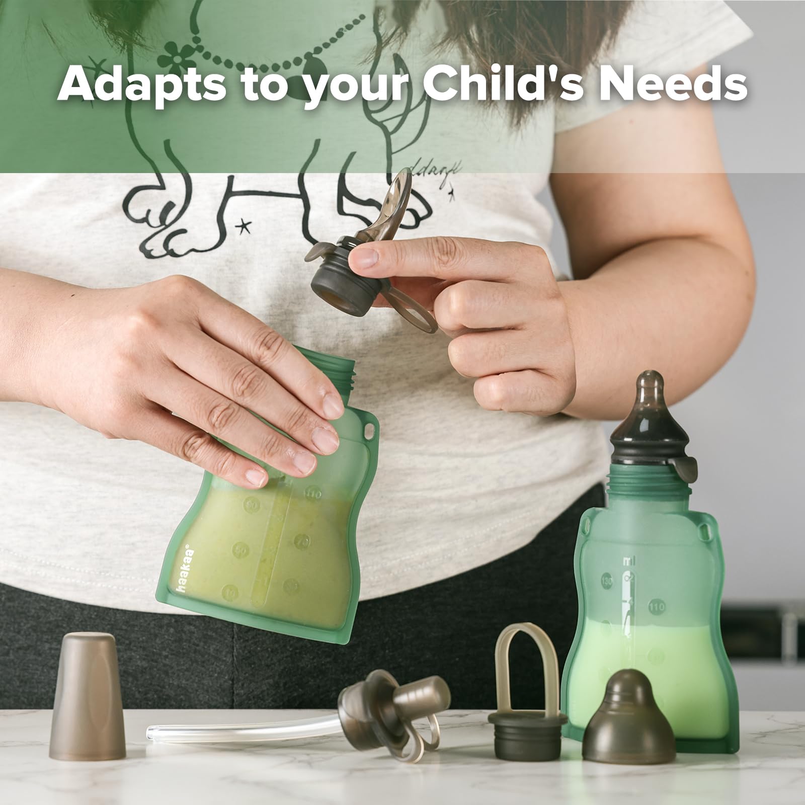 Toddler holding a Haakaa reusable squeezable food pouch