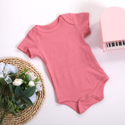 Folded cotton baby bodysuits and matching bibs assortment