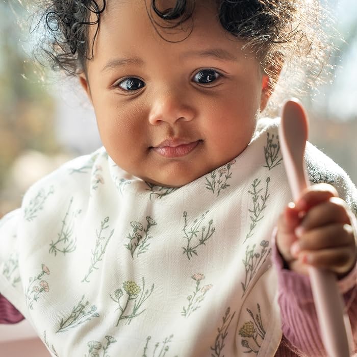 Parent using Aden + Anais burpy bib as a shoulder burp cloth