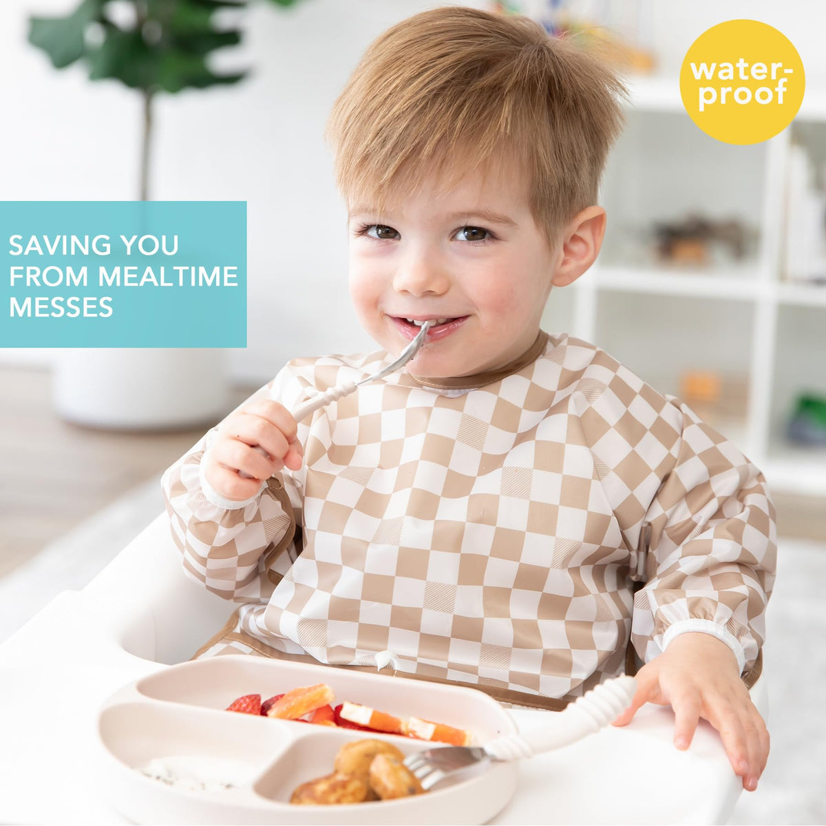 Baby wearing Bumkins waterproof sleeved bib for feeding