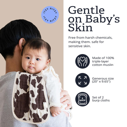 Parent using Itzy Ritzy cow print burp cloth over shoulder