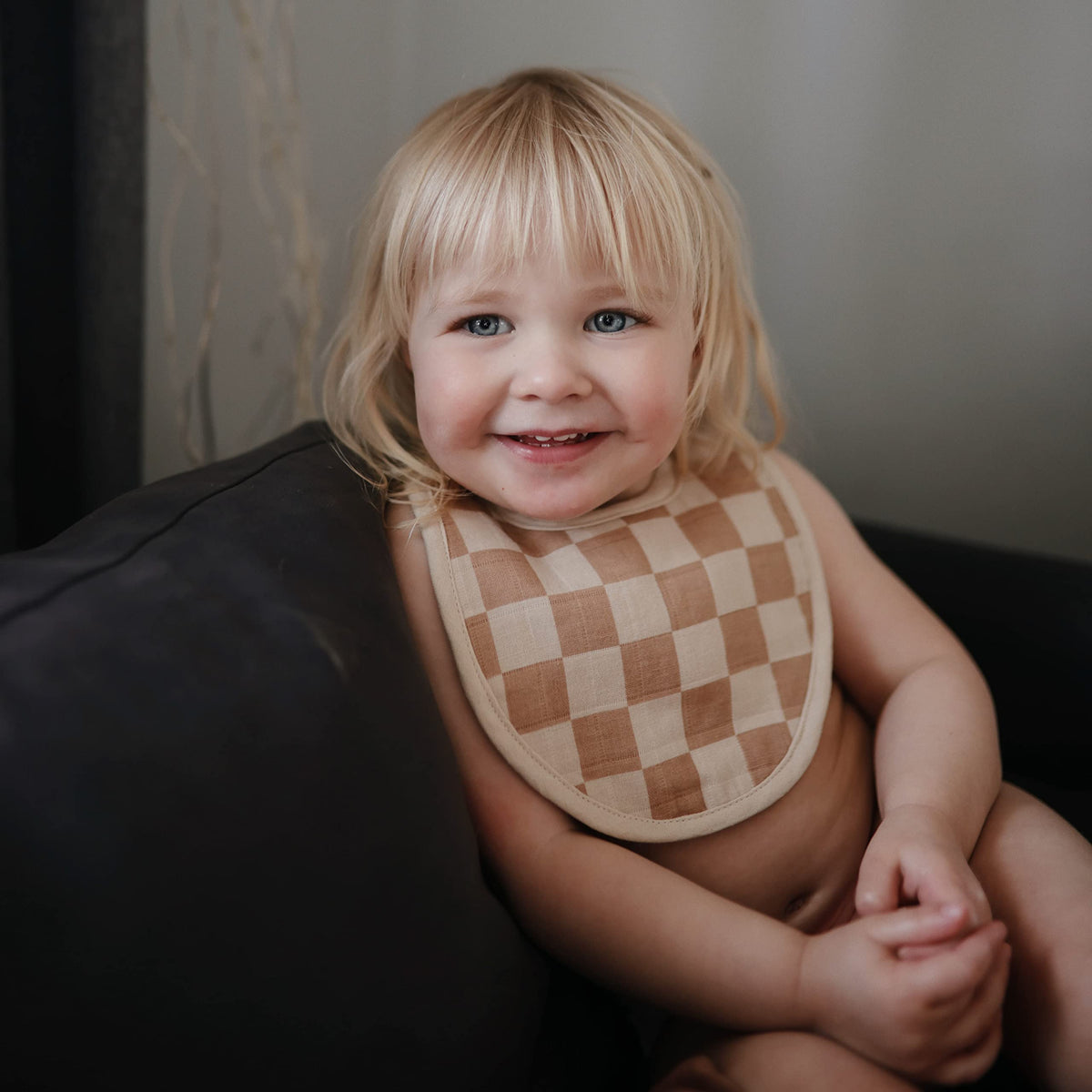 Close up of Mushie baby bib adjustable snap closure