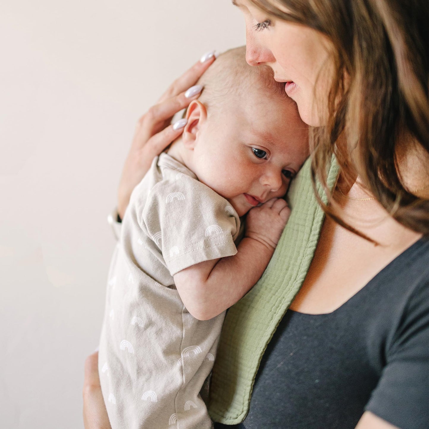 Parent using large muslin burp cloth over shoulder