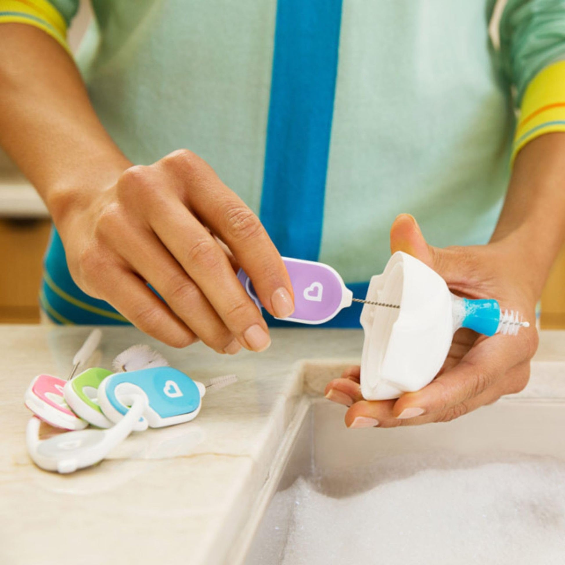 Using the Munchkin detail brush to clean sippy cup crevices