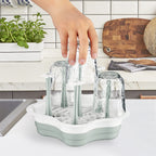 L-Wash drying rack holding various baby bottles and tumblers