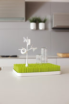 Boon twig accessory inserted into a grass drying rack holding bottle parts