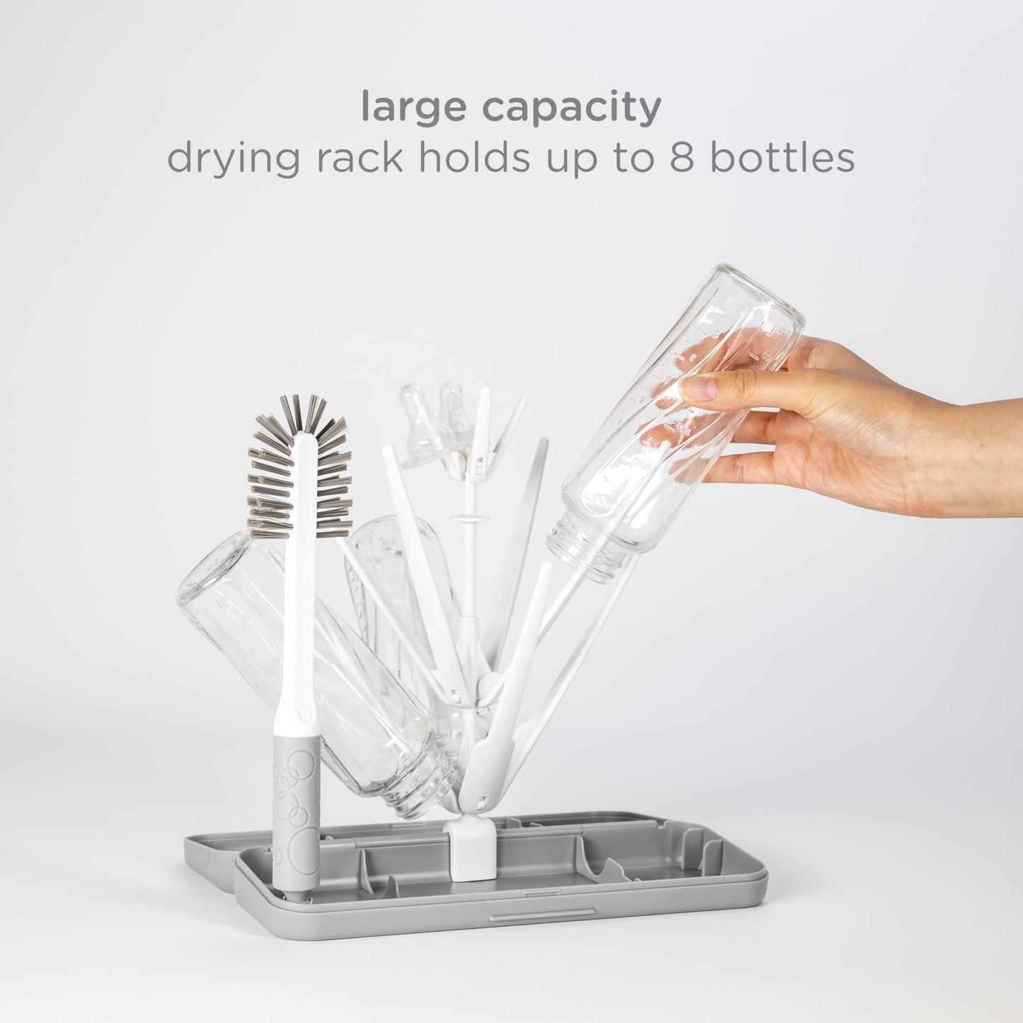 Ubbi drying rack holding baby bottles on kitchen counter