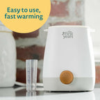The First Years bottle warmer showing integrated water vial and measuring guide