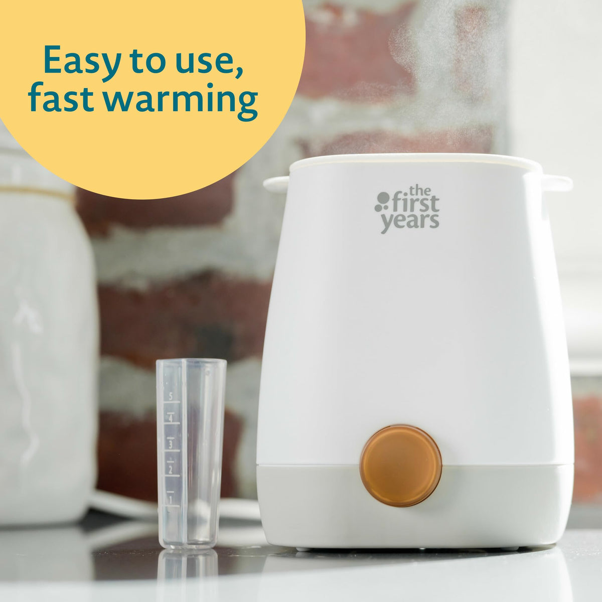 The First Years bottle warmer showing integrated water vial and measuring guide
