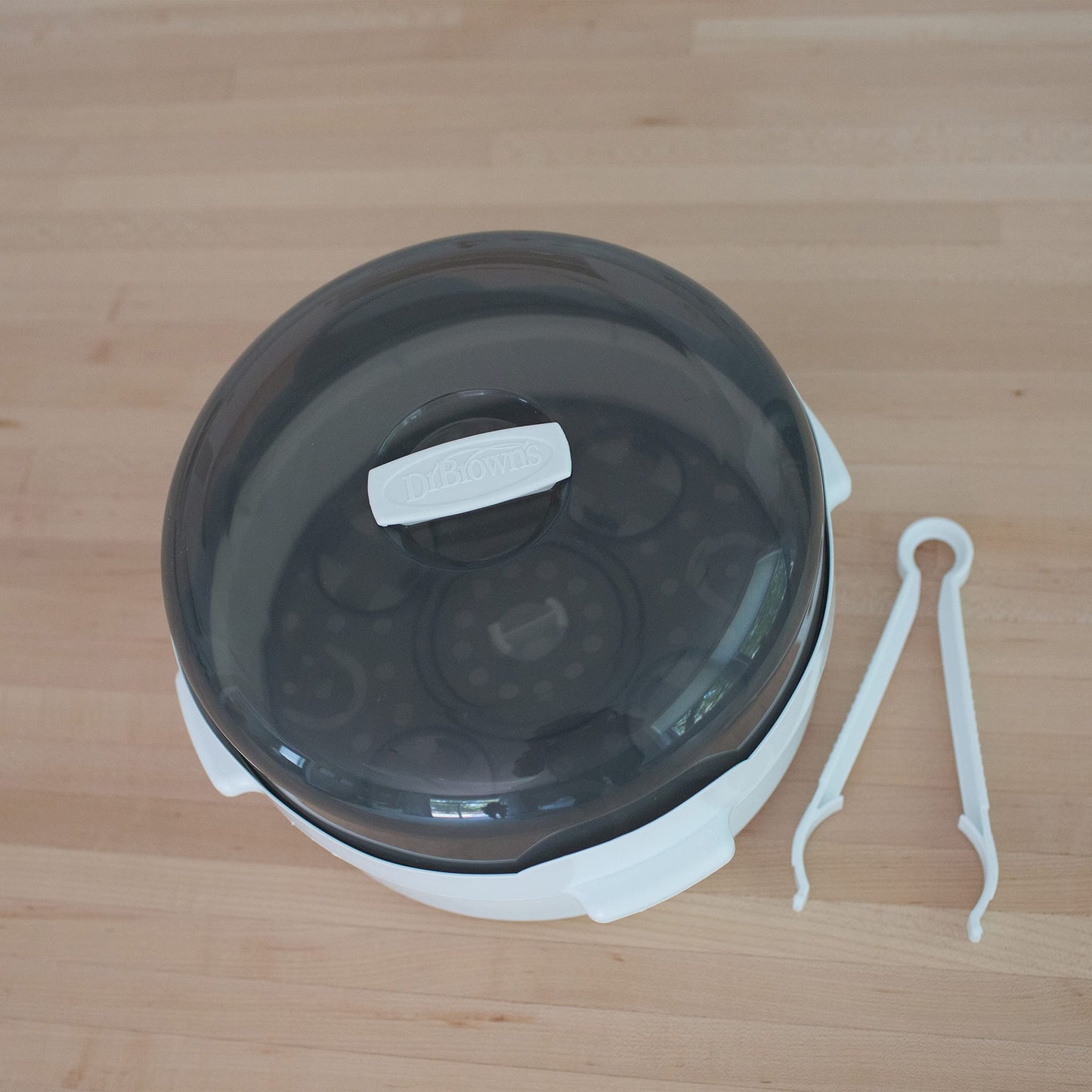 Safe handling of baby bottle parts with tongs