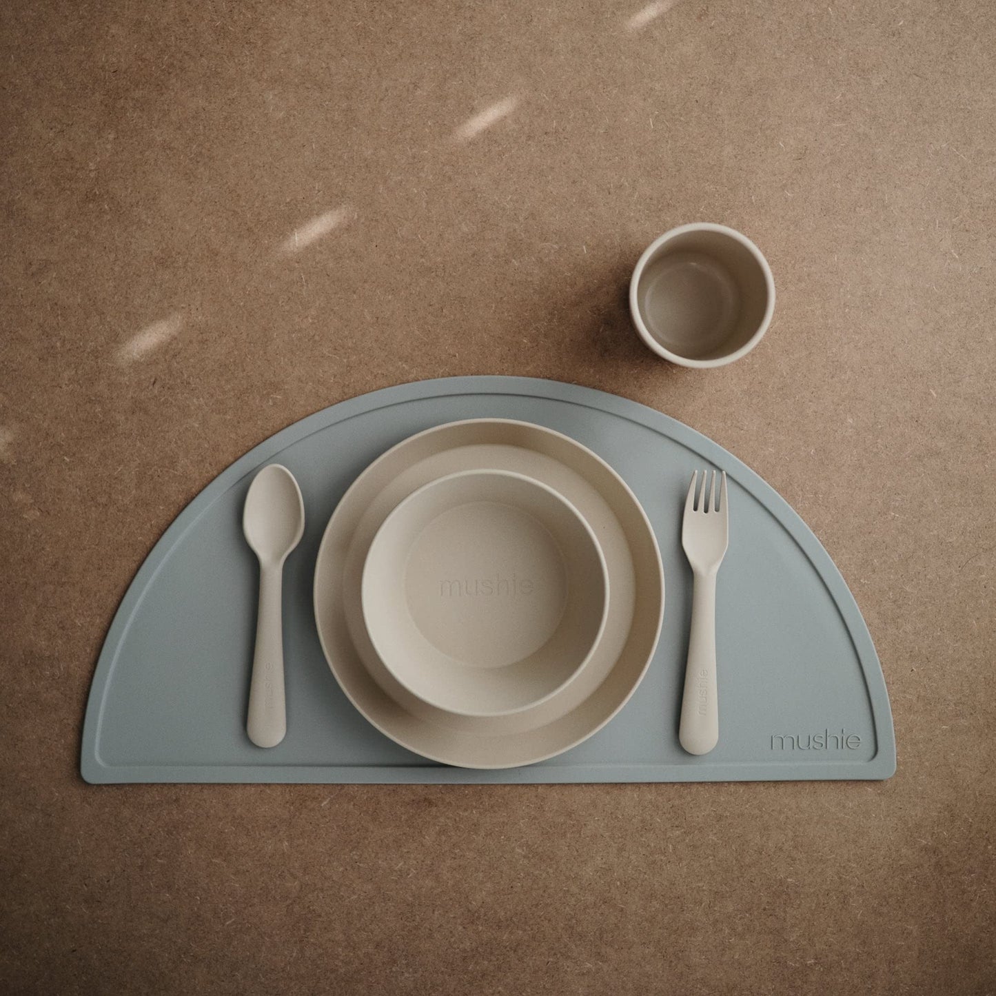 Toddler eating independently using Mushie round dinnerware bowl
