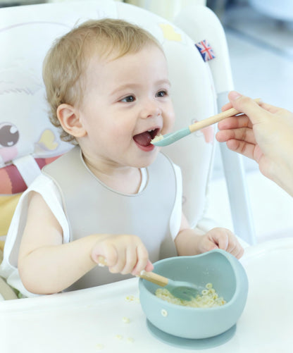 Ginbear adjustable silicone baby bib showing the wide crumb catcher pocket.