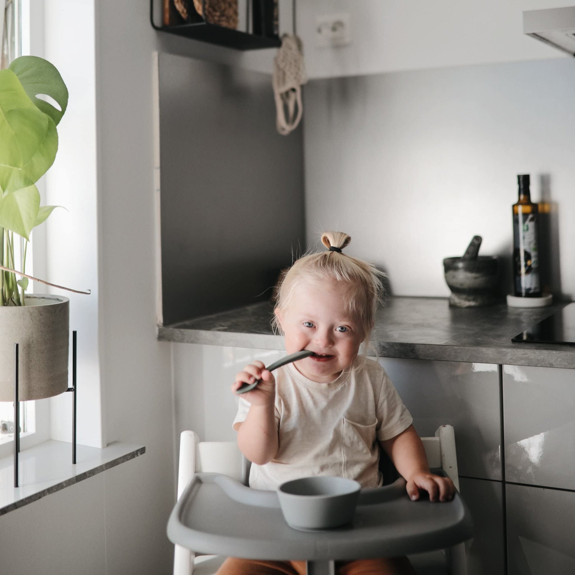 Mushie non-slip silicone bowl on a high chair tray