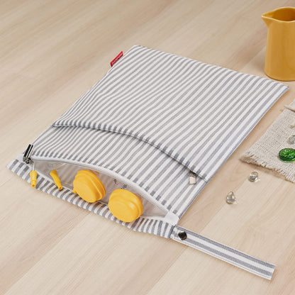 Discrete grey striped storage bag for breastfeeding mothers showing the dual zippered pockets