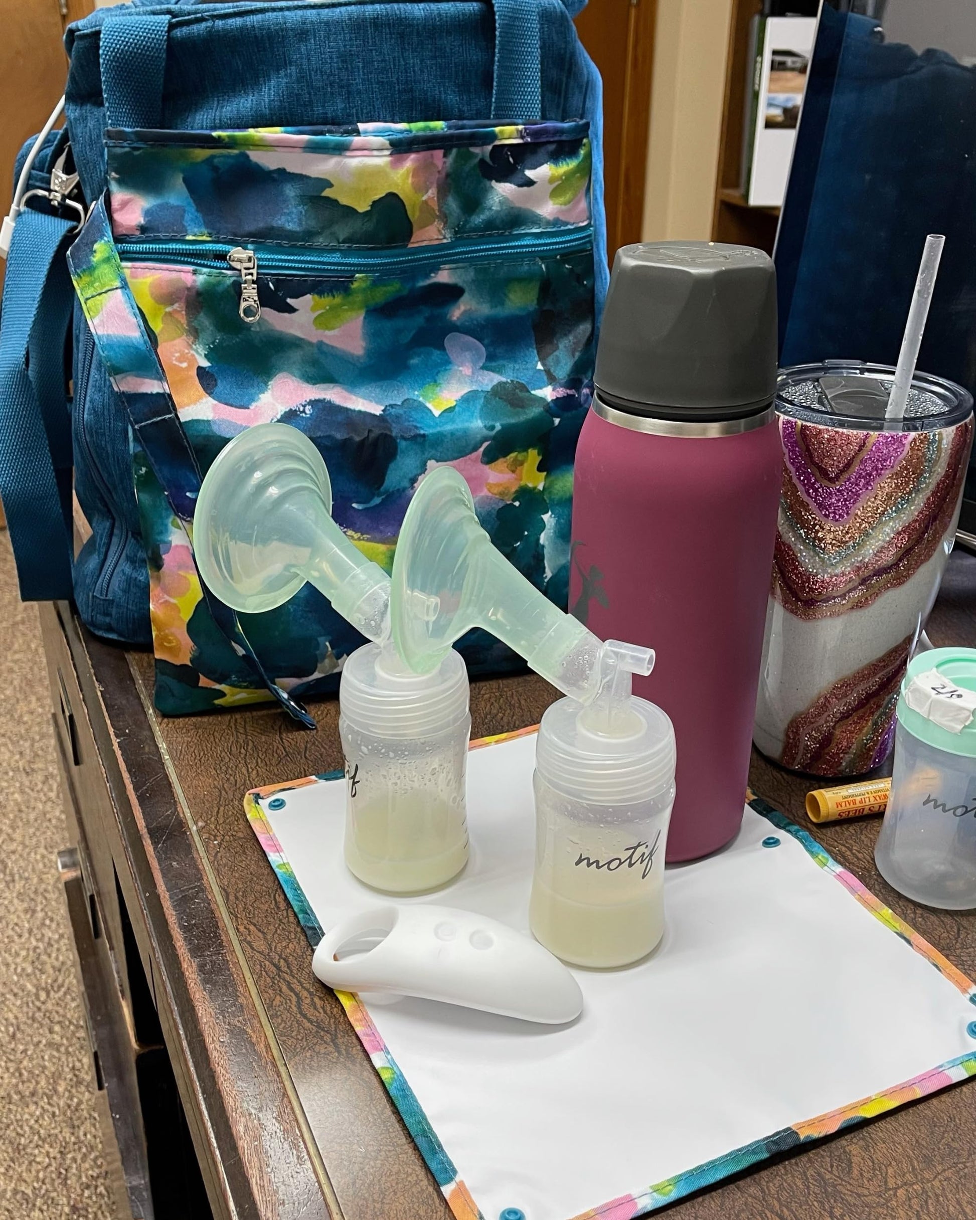Sarah Wells breast pump parts bag folded into quarters with wrist strap wrapped around