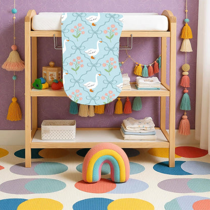 Wauprant gender neutral blue tones baby washcloths being used as a portable changing mat under an infant.