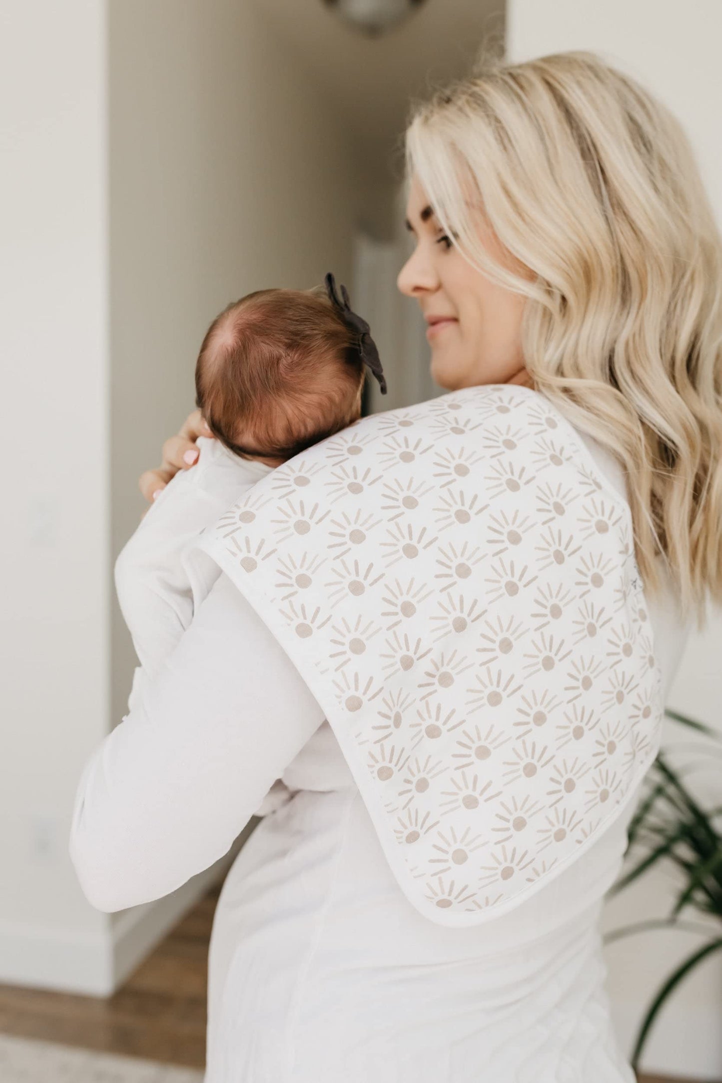 Parent using Copper Pearl burp cloth on shoulder