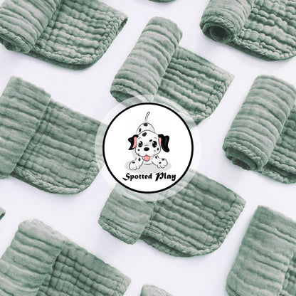 Twelve pack of extra soft green muslin spit up rags neatly stacked for nursery organization.