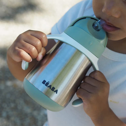 Close up of the spill proof slide mechanism on the sage green baby drinkware lid.