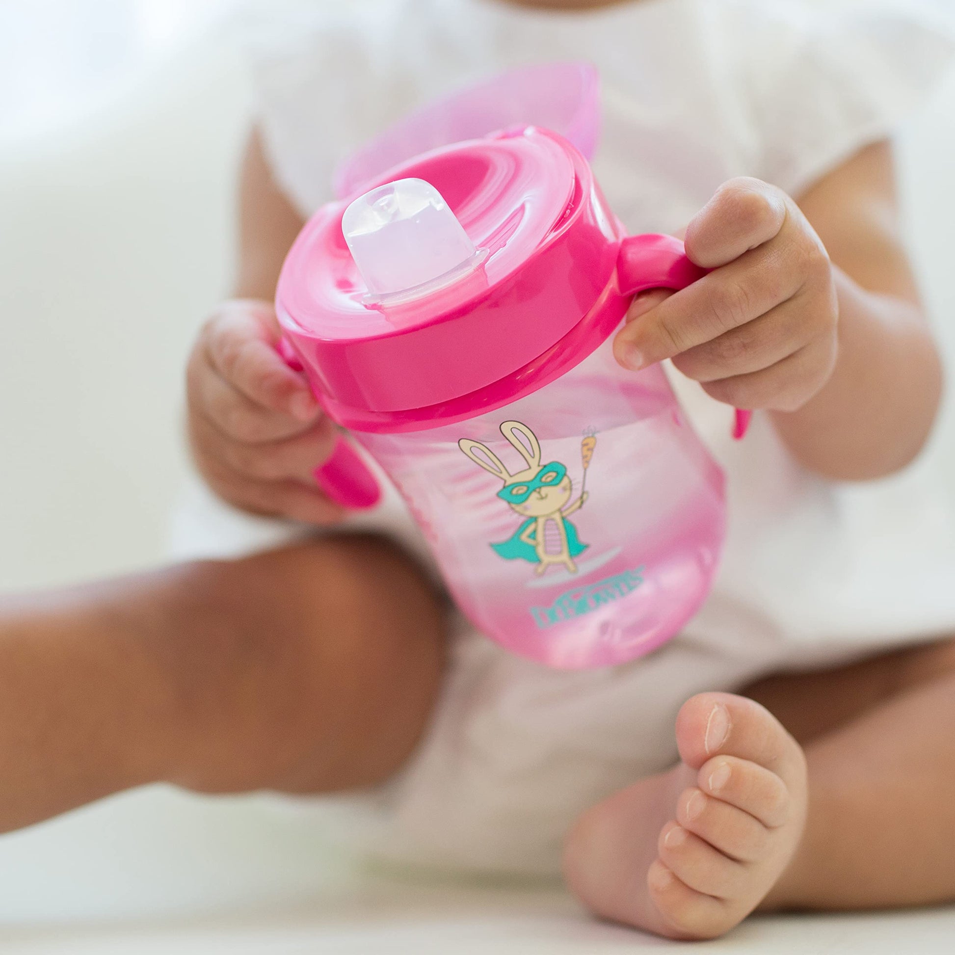 Dr. Brown's transition sipper cup with folding protective lid open for drinking.