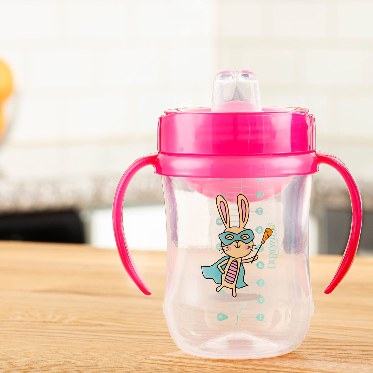 Infant hands holding the sturdy contoured handles of the Dr. Brown's Milestones transition cup.