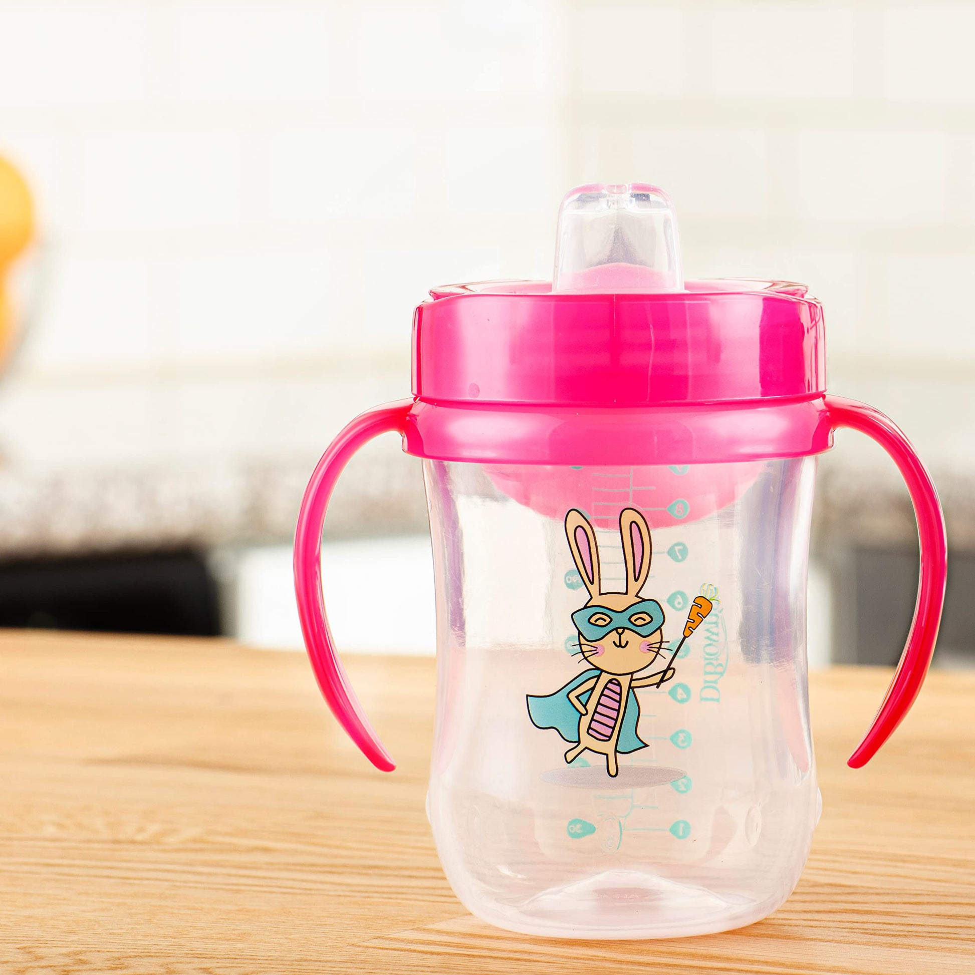 Infant hands holding the sturdy contoured handles of the Dr. Brown's Milestones transition cup.