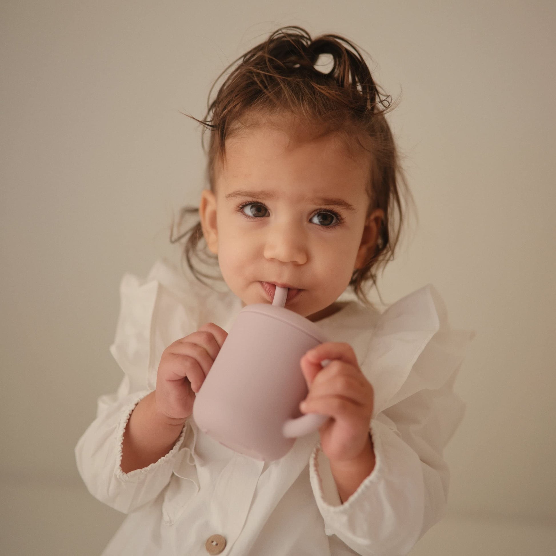Soft lilac Mushie training cup with angled silicone straw for toddlers