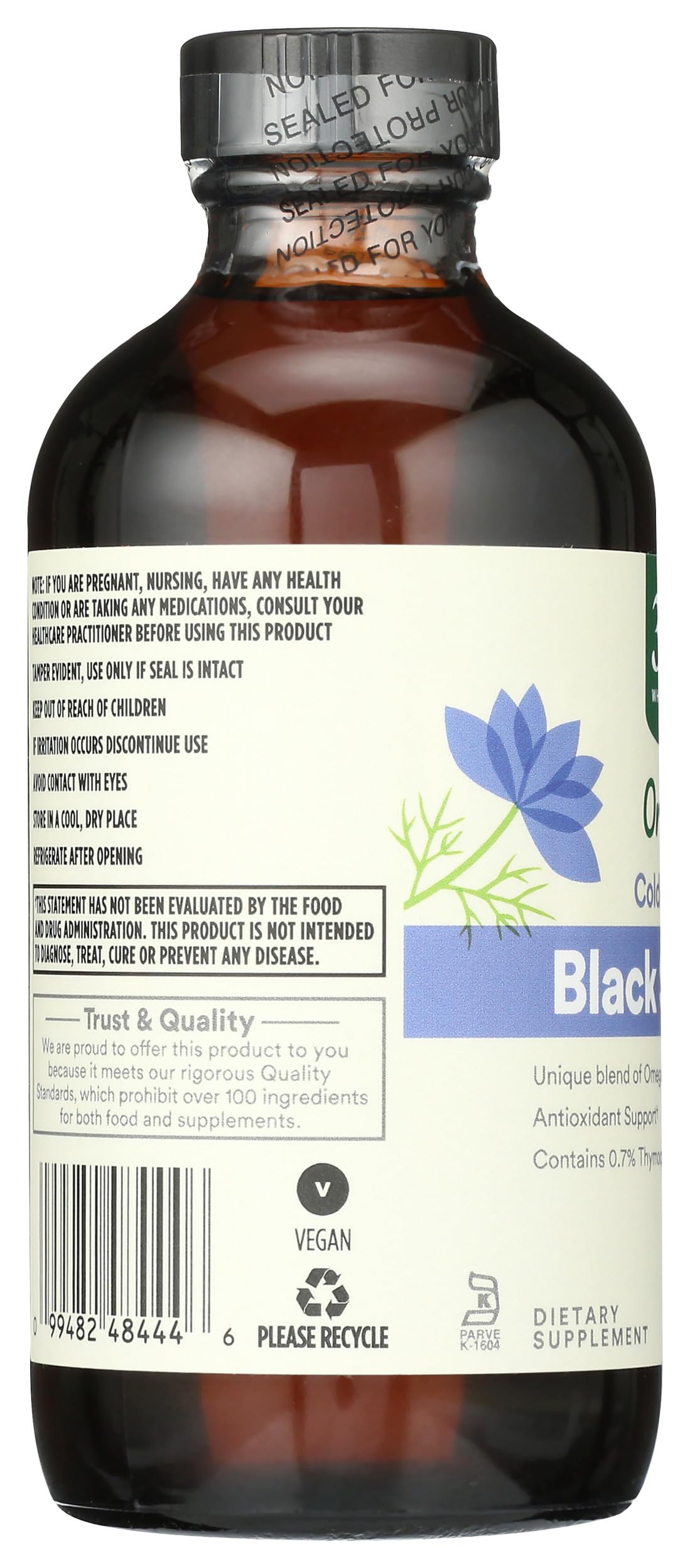 Pouring organic unrefined black cumin seed oil showing its rich natural golden texture