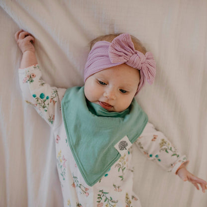 Detailed view of Parker Baby Co. bibs showing nickel-free snap closures