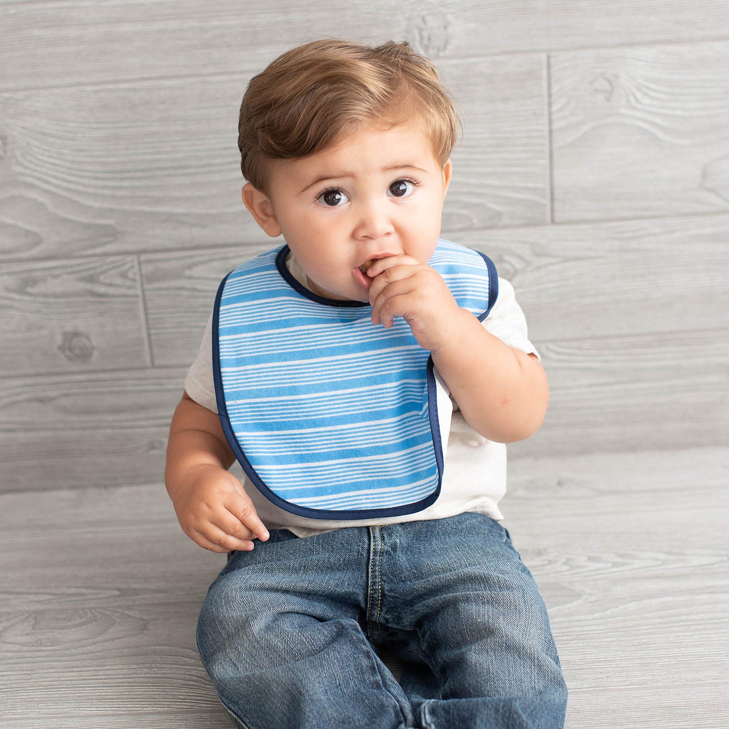 Neat Solutions baby boy feeding bibs spread out to display solid navy blue and patterned layouts