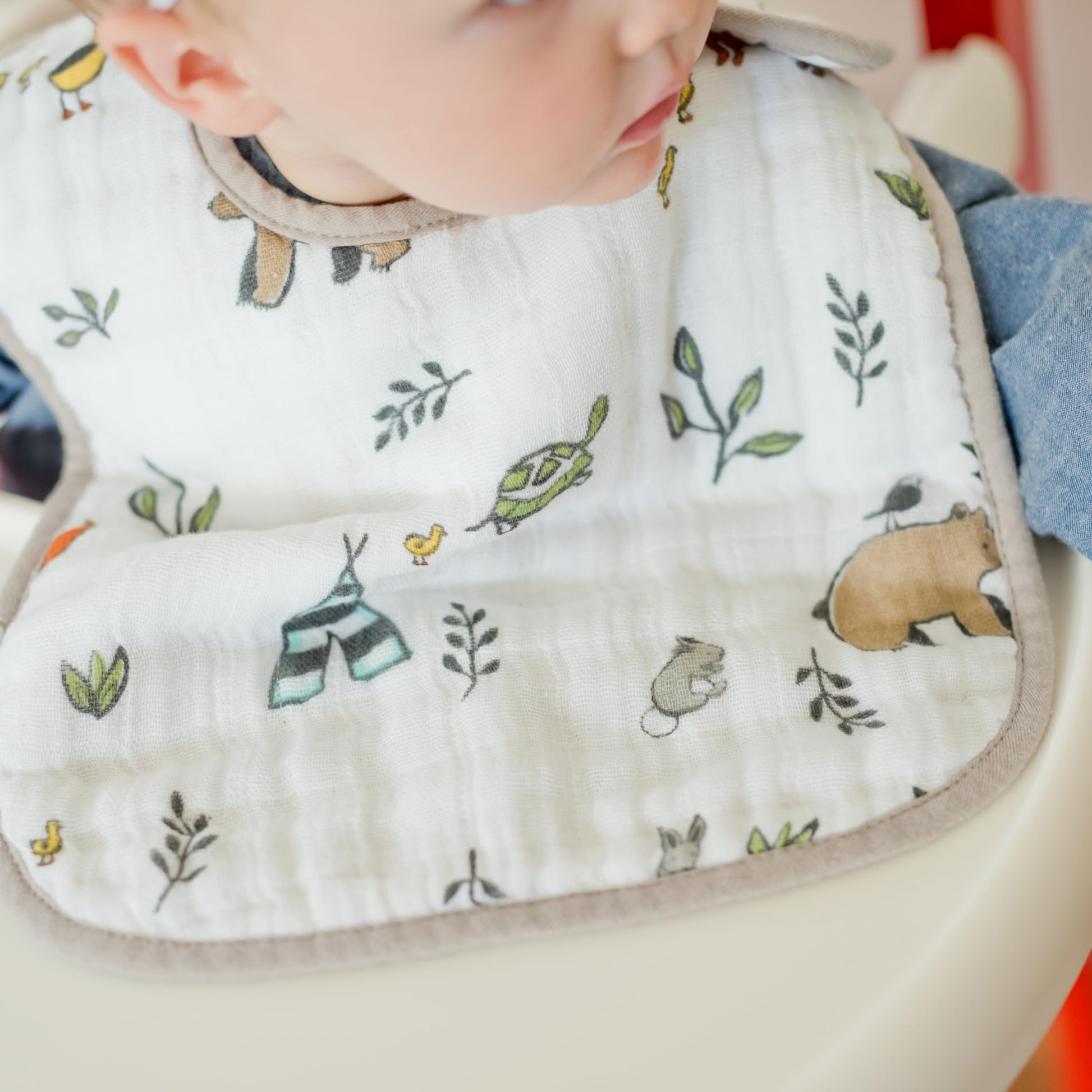 Adjustable neck sizing fit demonstration of Little Unicorn forest friends bib set