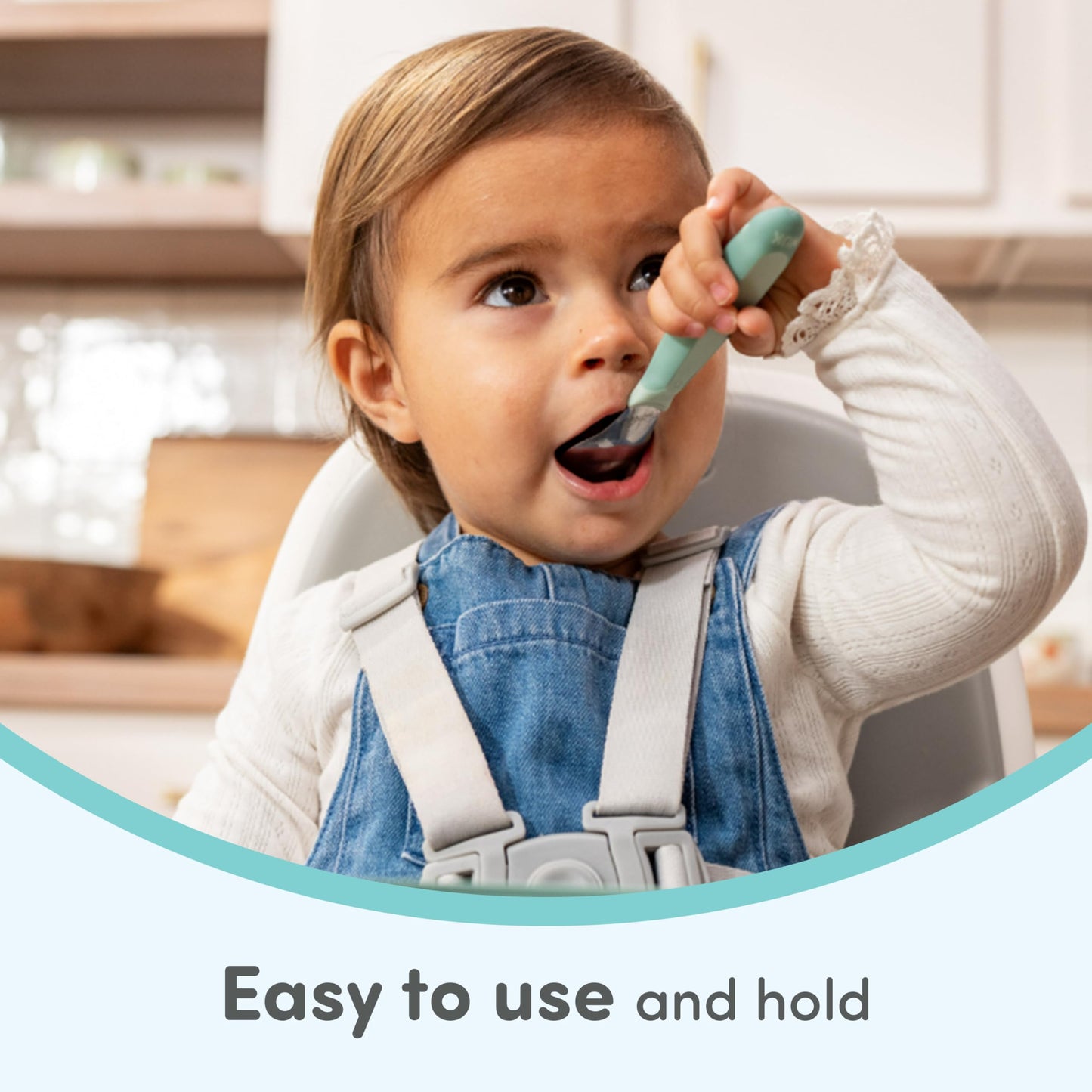 Toddler holding NUK Kiddy Cutlery fork for self feeding