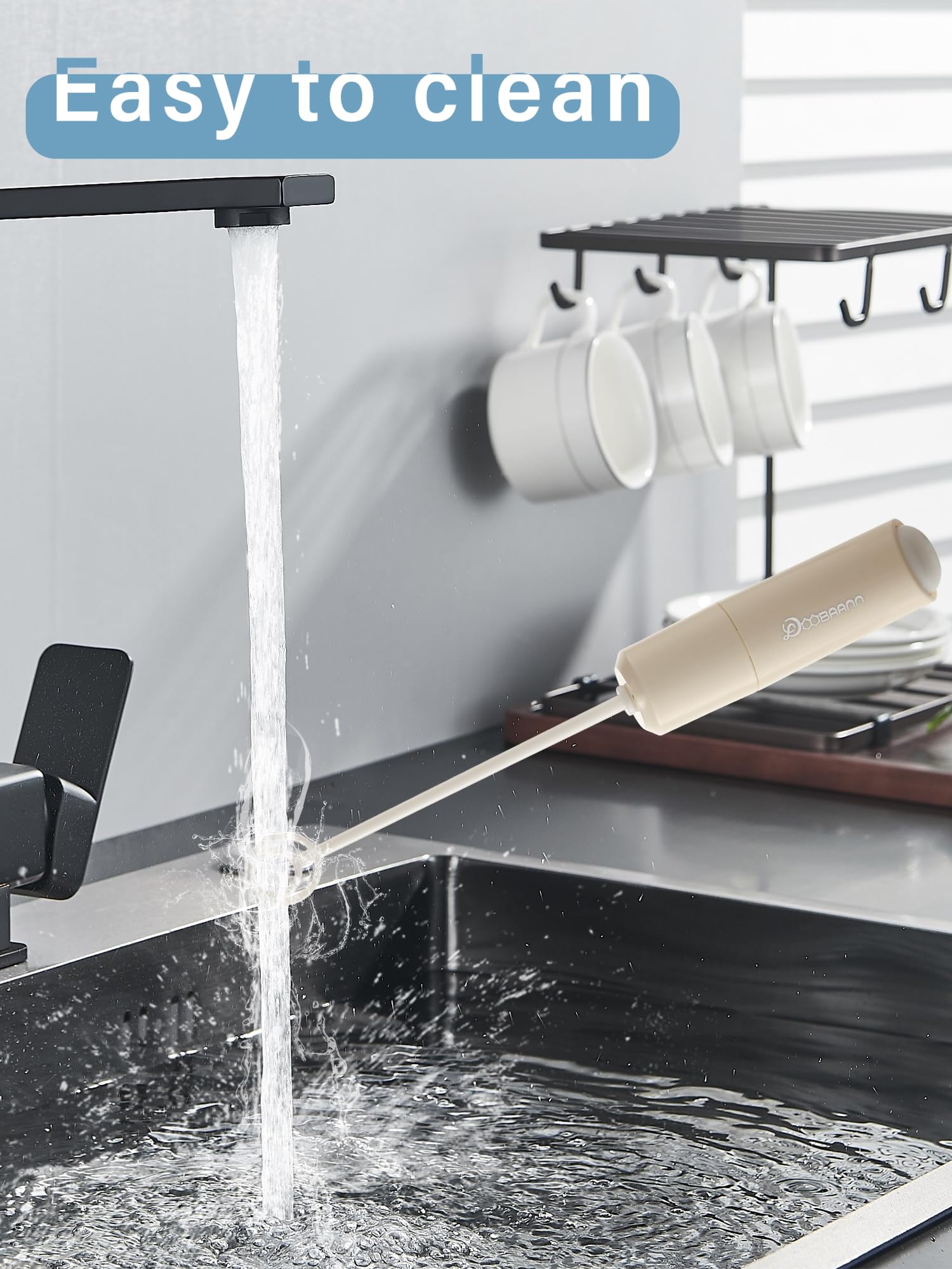 DOOBAANN battery operated small hand blender mixing a smooth latte coffee in a glass cup.