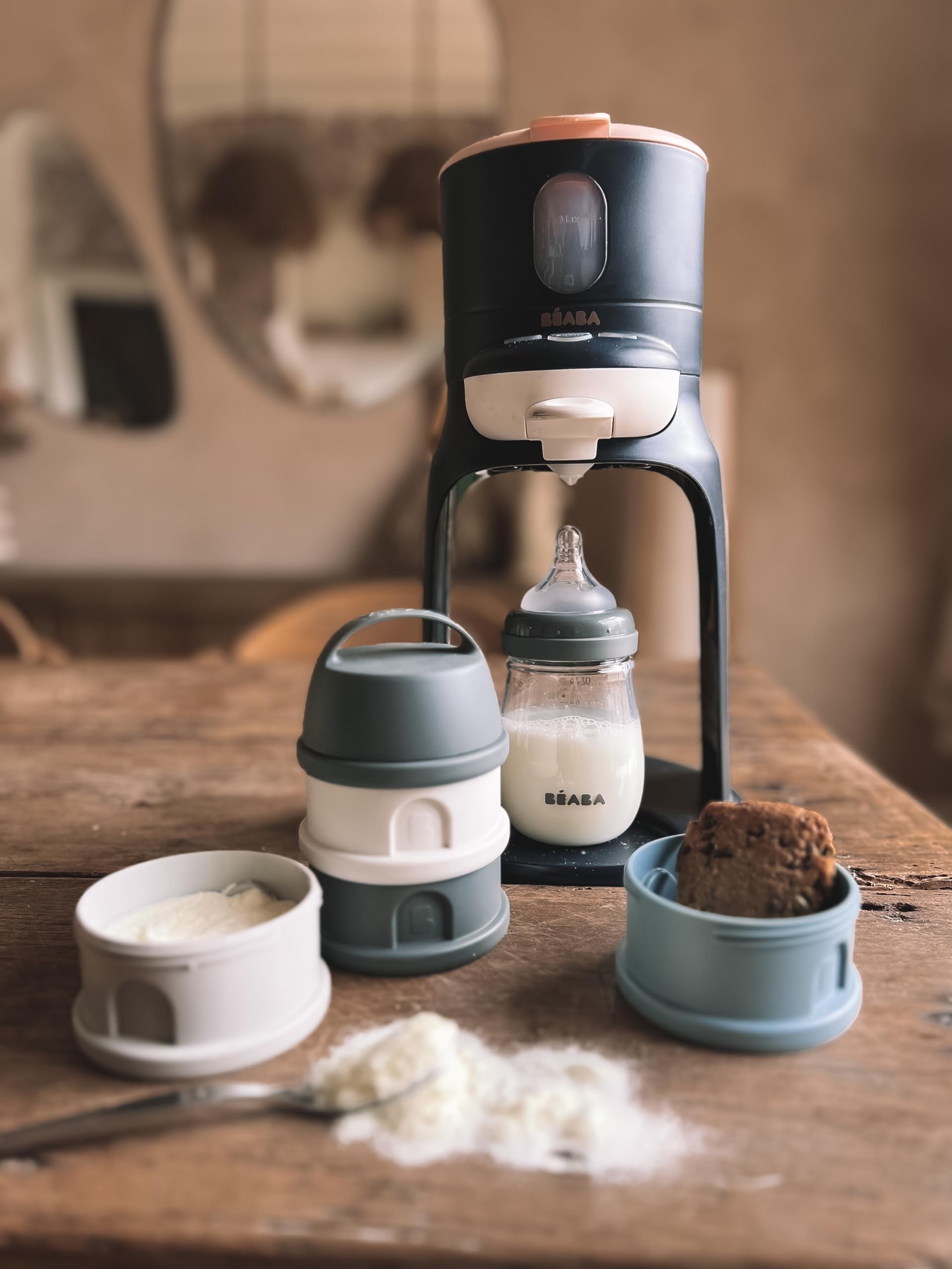 Béaba compact portable snack container system being prepared for an outdoor infant feeding session.