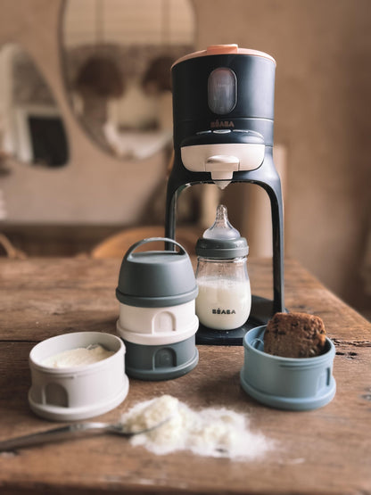 Béaba compact portable snack container system being prepared for an outdoor infant feeding session.