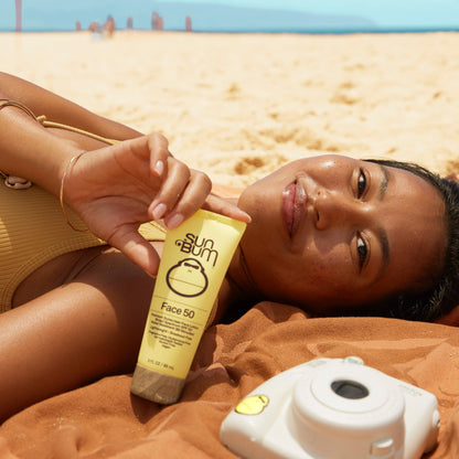 Sun Bum travel size sunscreen bottle held in hand