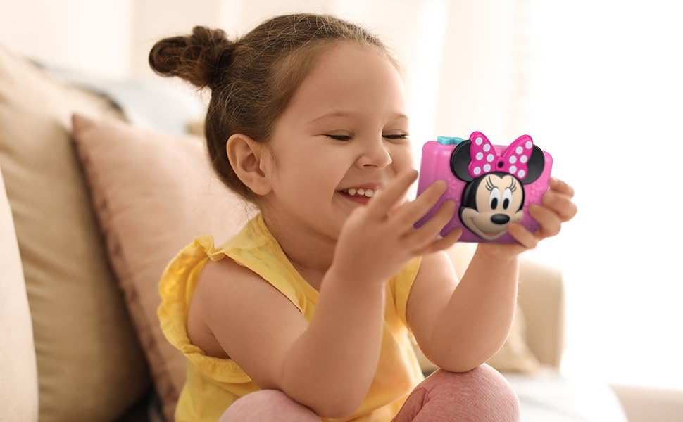 Minnie Mouse official licensed digital video camera showing the built-in selfie lens and wrist strap attachment.