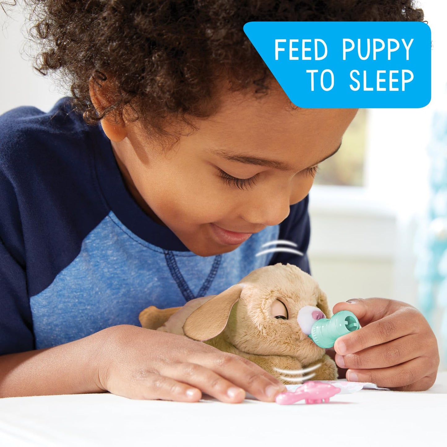 Small electronic plush puppy wrapped cozy inside its blue patterned swaddling blanket.