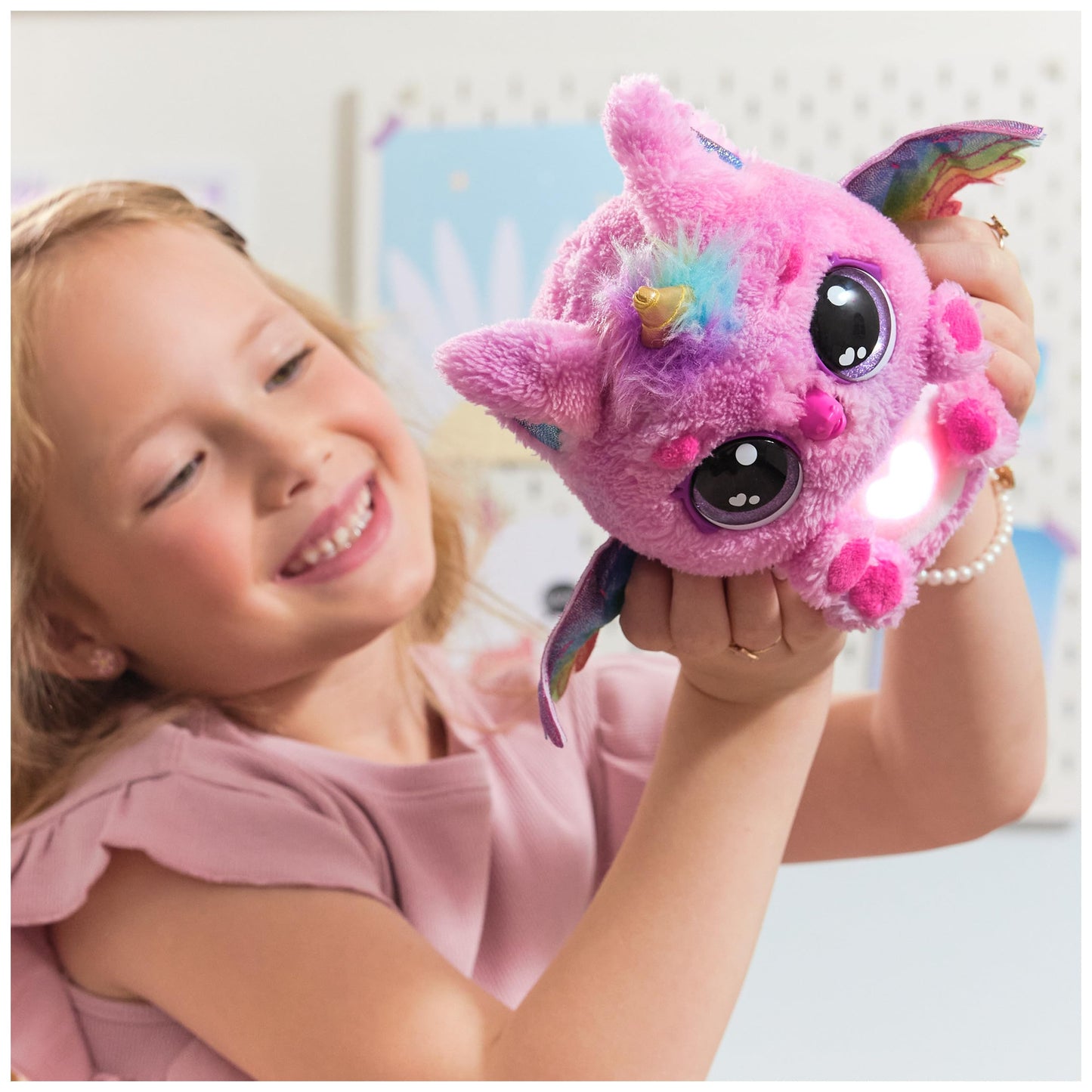 Side profile of the interactive plush unicorn toy highlighting the wing mechanism and colorful soft fabric.